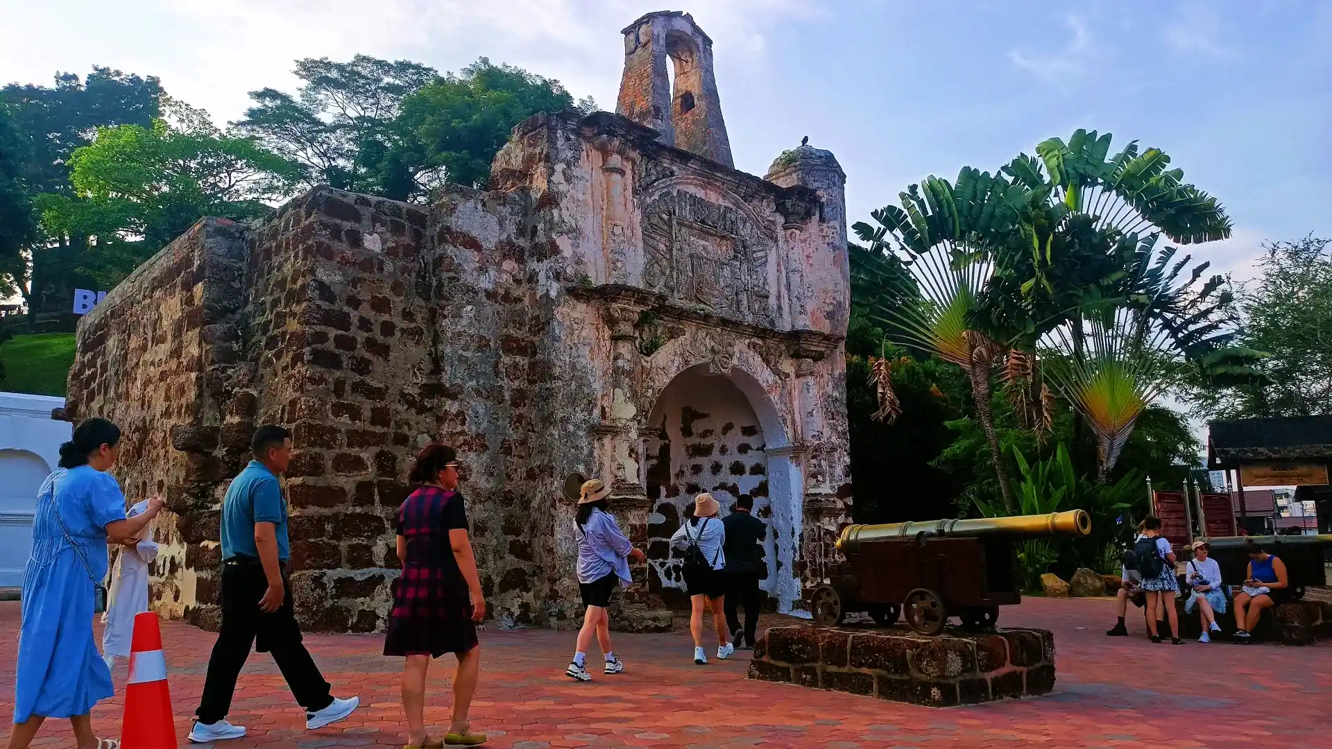 The A Famosa gate, Porta de Santiago, with visitors and an old cannon in front of it