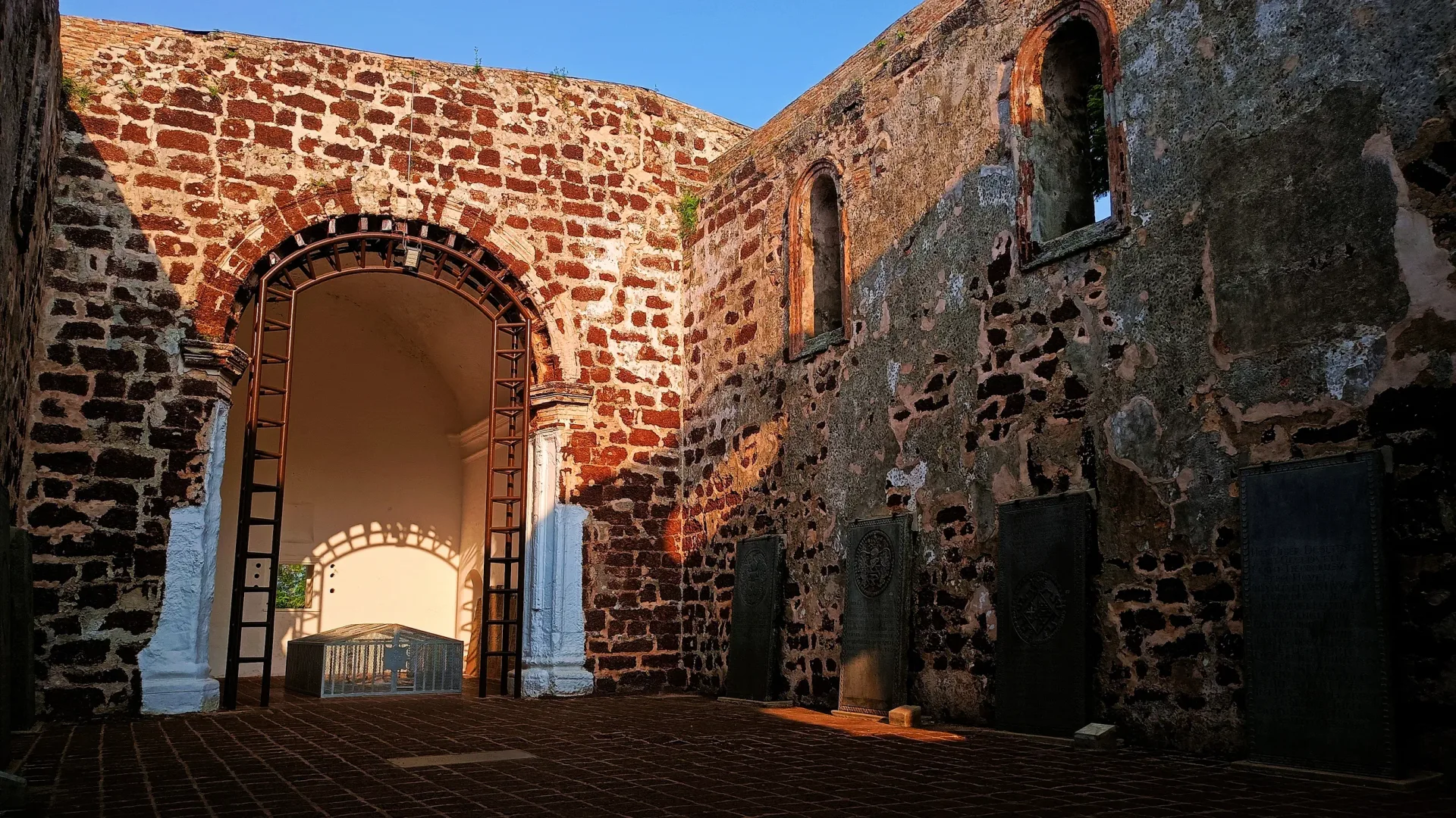 Inside the roofless ruins of St Paul's Church, with old tombstones propped against the walls